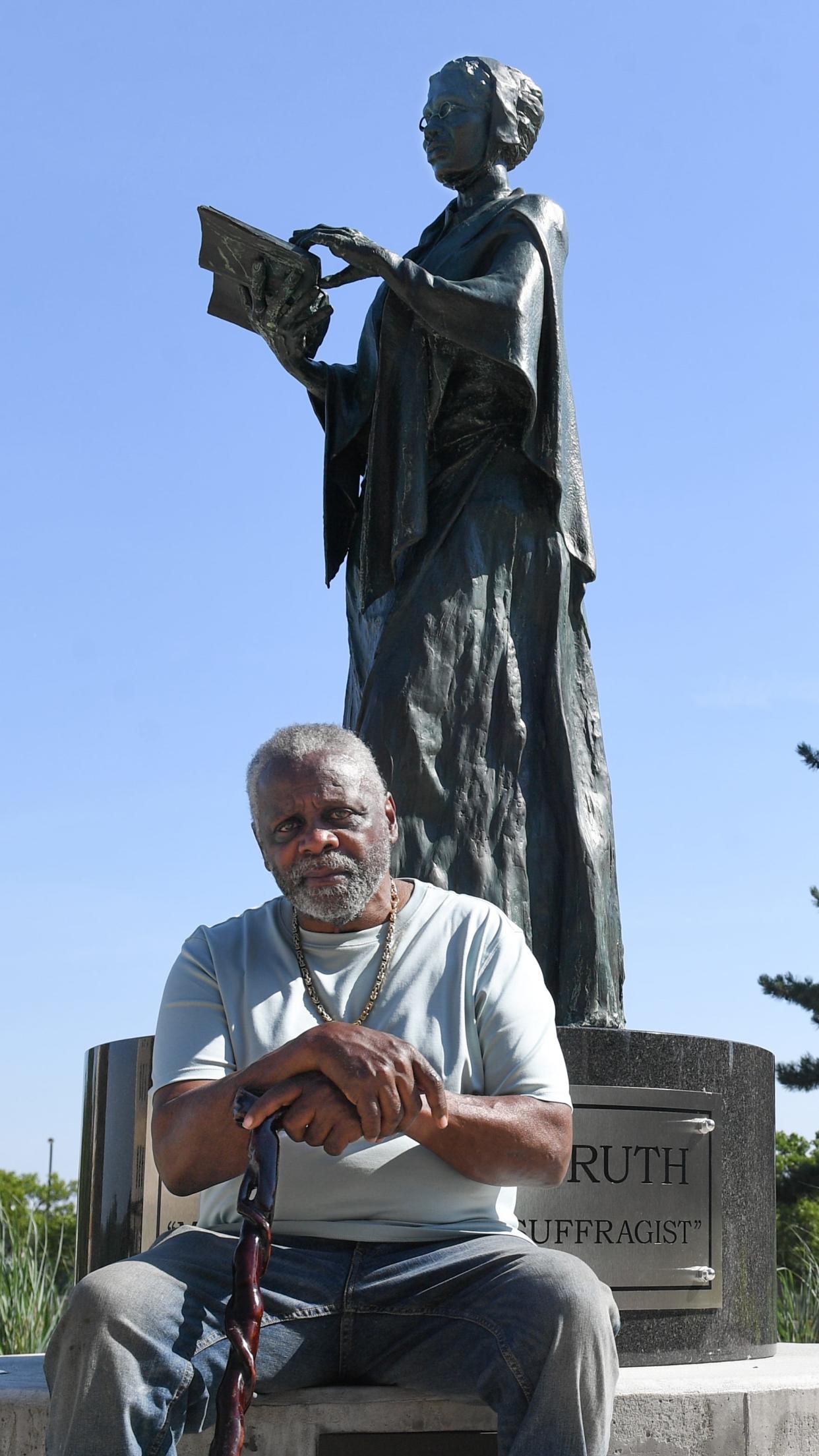 Artist Woodrow Nash poses July 3 for a portrait with the bronze statue of Sojourner Truth that he created for the Sojourner Truth Legacy Plaza at the United Way in downtown Akron.