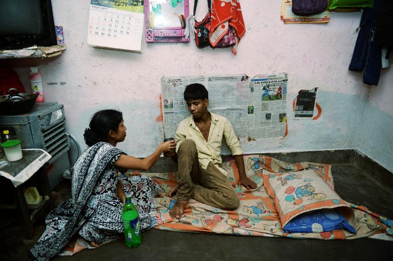 Indian resident Mohammad Awwal, 18, who is suffering from dengue fever, rests on the ground at his home in New Delhi on October 2, 2013