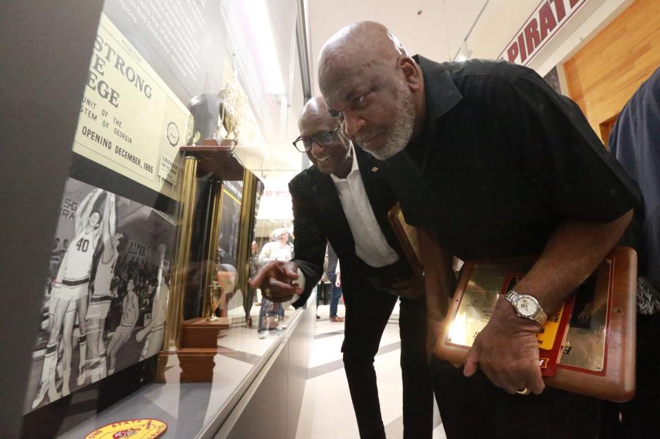 Former Armstrong basketball players and Armstrong Sports Hall of Fame members Ike Williams, left, and Elijah "Sonny" Powell check out a photo in the basketball display case at the Armstrong Hall of Champions in February.