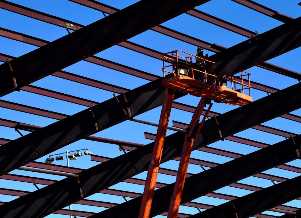 A hydraulic lift carries an iron worker to the steel beams over the The Nest at Abilene High School on Thursday. The indoor facility will be identical to The Den under construction at Cooper High School.