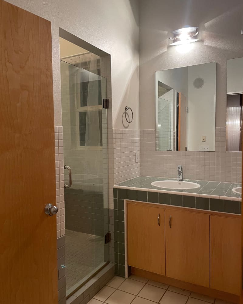 White and green tiles in bathroom before renovation.