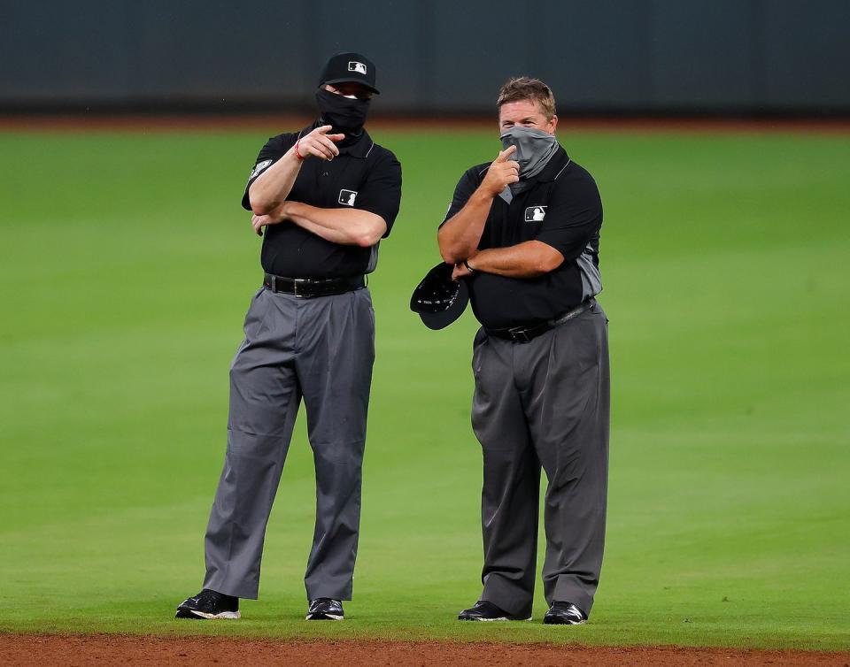 <p>Umpires Carlos Torres #37 and Marvin Hudson #51 converse during an exhibition game between the Atlanta Braves and the Miami Marlins at Truist Park on July 21.</p>