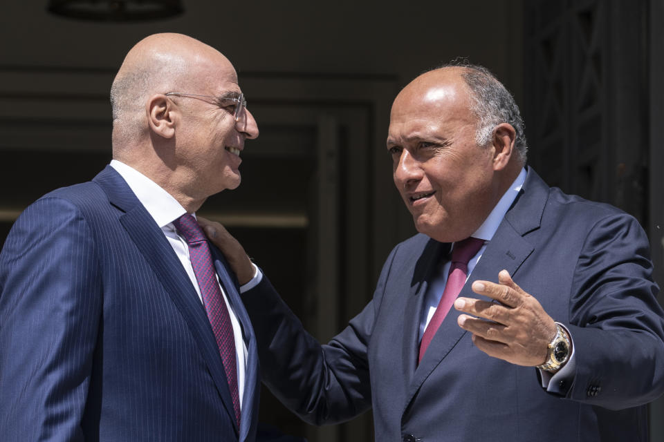 Greek Foreign Minister, Nikos Dendias, left, welcomes his Egyptian counterpart Sameh Shoukry , as they meet in Athens on Tuesday, April 11, 2023. Greece and Egypt have close military ties and are planning to build an undersea electricity grid connector across the Mediterranean. (AP Photo/Petros Giannakouris)