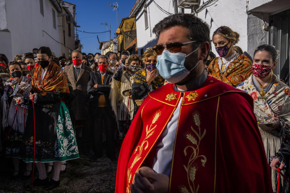 FILE - Catholic worshippers gather during the procession as part of the "Las Carantonas" festival in Acehuche, southeast Spain, Friday, Jan. 21, 2022. The Spanish government on Tuesday, July 4, 2023, declared an end to the health crisis caused by the COVID-19 pandemic, and says people no longer have to wear masks in health and care centers as well as pharmacies. (AP Photo/Bernat Armangue, File)