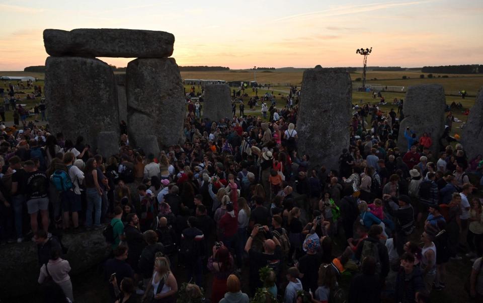 A crowd flocked to watch the sun set at Stonehenge - JUSTIN TALLIS/AFP