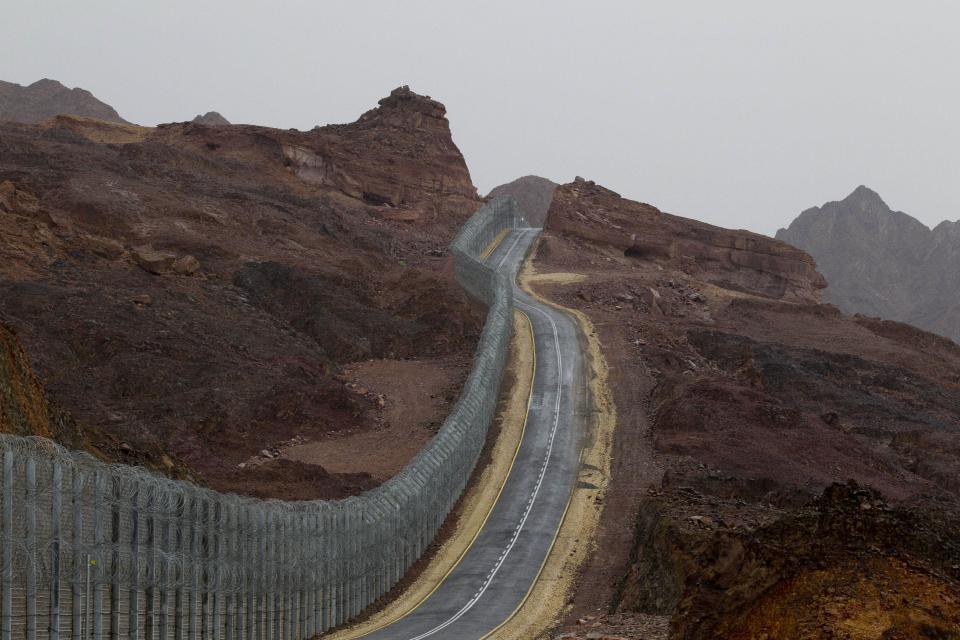 A street runs along the Egypt-Israel border security barrier near the Red Sea resort city of Eilat, southern Israel, Sunday, March 9, 2014. A senior security official in Egypt said a missile shipment seized by Israel last week was destined for militants in either the Sinai Peninsula or the Gaza Strip. (AP Photo/Ariel Schalit)