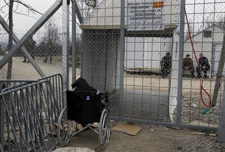 Stranded wheelchair-bound Zhino Hasan, 17, is seen in front of the closed Idomeni border gate, hoping that Macedonia would relent and allow her and her family to resume their northward trek through the Balkans to Germany February 26, 2016. REUTERS/Yannis Behrakis