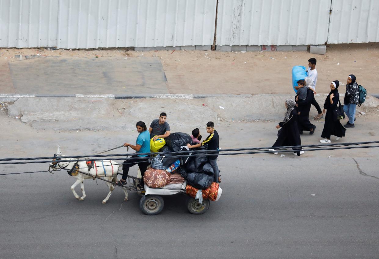 Palestinians fleeing their homes amid Israeli strikes, ride a donkey cart carrying their belongings, in Gaza City on 10 October 2023. (Reuters)
