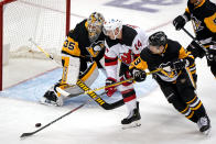 New Jersey Devils' Nathan Bastian (14) backhands a shot past Pittsburgh Penguins goaltender Tristan Jarry (35) with Evan Rodrigues (9) defending during the third period of an NHL hockey game in Pittsburgh, Tuesday, April 20, 2021. (AP Photo/Gene J. Puskar)