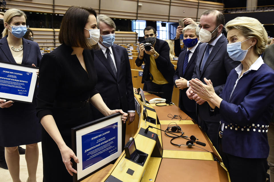 Belarusian opposition politician Sviatlana Tsikhanouskaya, second left, is applauded by European Commission President Ursula von der Leyen, right, at the end of the Sakharov Prize ceremony at the European Parliament in Brussels, Wednesday, Dec. 16, 2020. The European Union has awarded its top human rights prize to the Belarusian democratic opposition. (John Thys/Pool Photo via AP)