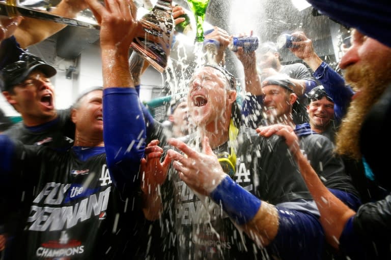 The Los Angeles Dodgers players celebrate in the clubhouse after defeating the Chicago Cubs in game five of the National League Championship Series, at Wrigley Field in Chicago, Illinois, on October 19, 2017