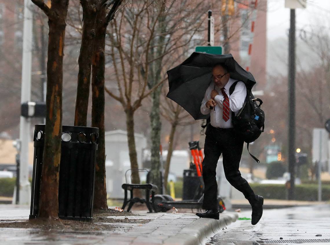 A person crosses Corcoran Street as a winter storm brings heavy rain and wind on Tuesday, Jan. 9, 2024, in Durham, N.C.