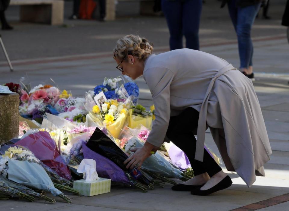 People lay down flowers ahead of a vigil in Albert Square (AP)