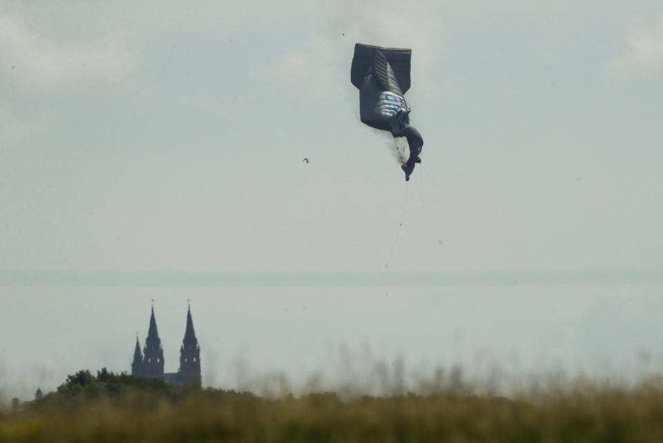 FILE - In this June 15, 2017 file photo, a blimp crashes during the first round of the U.S. Open golf tournament near Erin Hills in Erin, Wis. The pilot - the sole passenger - was badly injured but survived, according to a National Transportation Safety Board investigation. Patrick Parker Walsh's bid to save his aerial advertising businesses started out legitimately but quickly escalated into sizeable fraud. In the wake of the crash, Walsh’s clients began to bail, his attorneys wrote in court filings. To stay afloat, he obtained high-interest loans that also allowed him to expand his businesses. By 2019, his companies had sales of $16 million and had expanded into Latin America and Asian markets. Then the pandemic hit. “COVID-19 did not slow down business, it killed it,” Walsh’s attorneys wrote. (AP Photo/Charlie Riedel File)