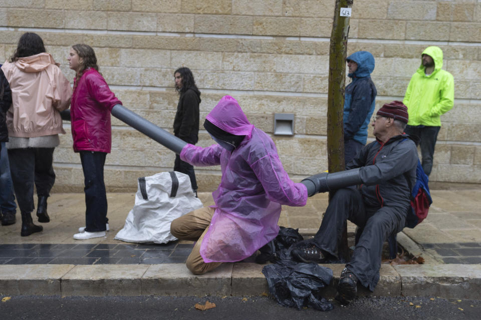 Demonstrators and activists block a road near the Ministry of Foreign Affairs and other government offices over plans by Prime Minister Benjamin Netanyahu's government to overhaul the judicial system, in Jerusalem, Tuesday, March 14, 2023. (AP Photo/Ohad Zwigenberg)