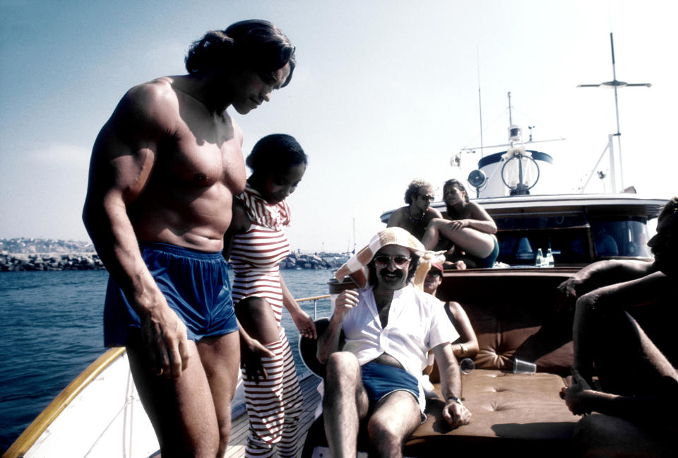 <p>De fiesta junto al cantante italiano Giorgio Moroder, así captaron al también deportista en 1979 en Los Ángeles. Ese año apareció en las películas 'Cactus Jack' (1979) y 'Tonto el último' (1979). (Foto: Michael Ochs Archives / Getty Images)</p> 