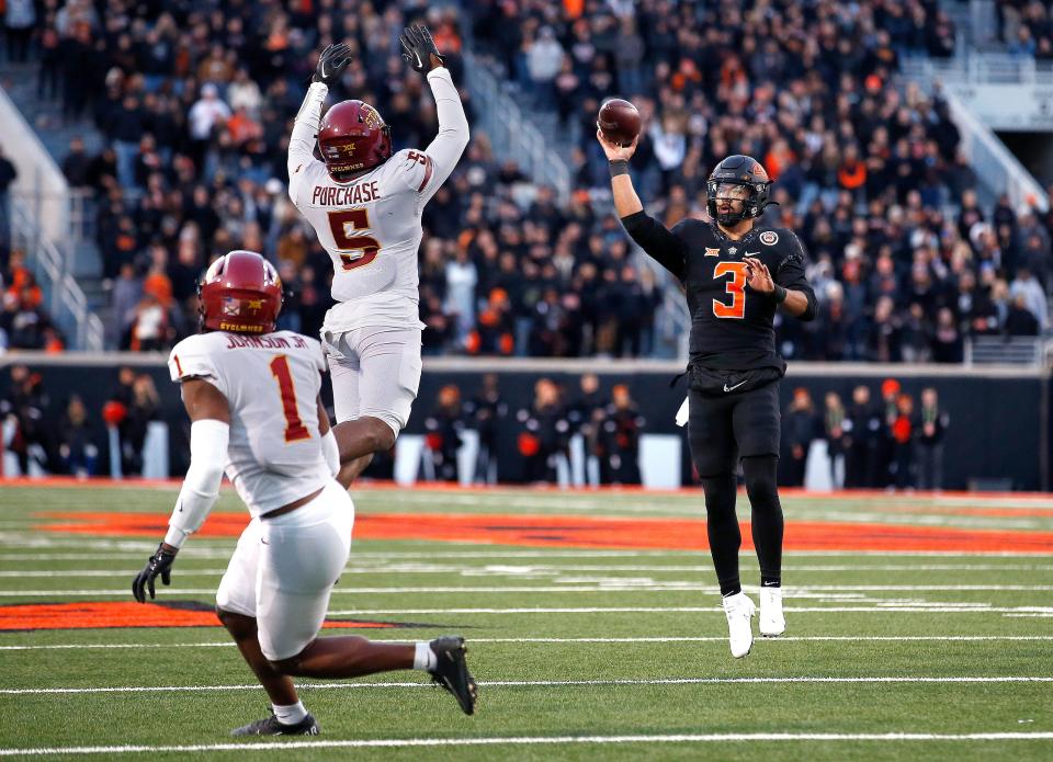 Nov 12, 2022; Stillwater, Oklahoma, USA;  Oklahoma State's Spencer Sanders (3) throws a touchdown pass over Iowa State's Myles Purchase (5) and Anthony Johnson Jr. (1) in the fourth quarter during the college football game between the Oklahoma State Cowboys (OSU) and the Iowa State Cyclones at Boone Pickens Stadium. OSU won 20-14. Mandatory Credit: Sarah Phipps-USA TODAY Sports