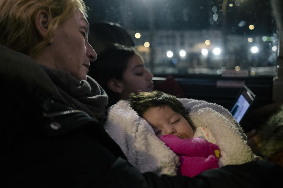 Elsa Brito, a la izquierda, sostiene a su nieta de dos meses, Amber Peña, mientras duermen a bordo de un autobús que se dirige a la frontera con Canadá, en Albany, Nueva York, el 5 de febrero de 2023. (José A. Alvarado Jr./The New York Times).