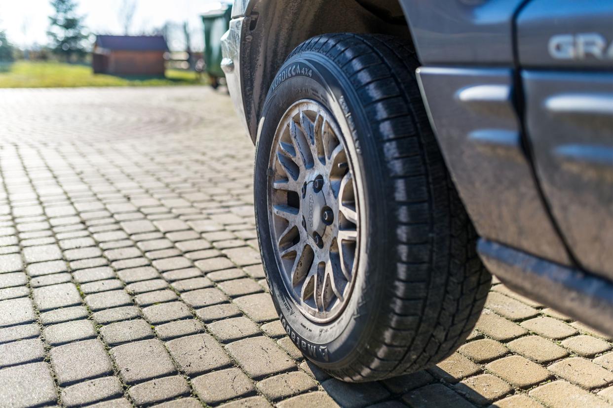 Closeup of a Jeep wheel on a cobbled street.