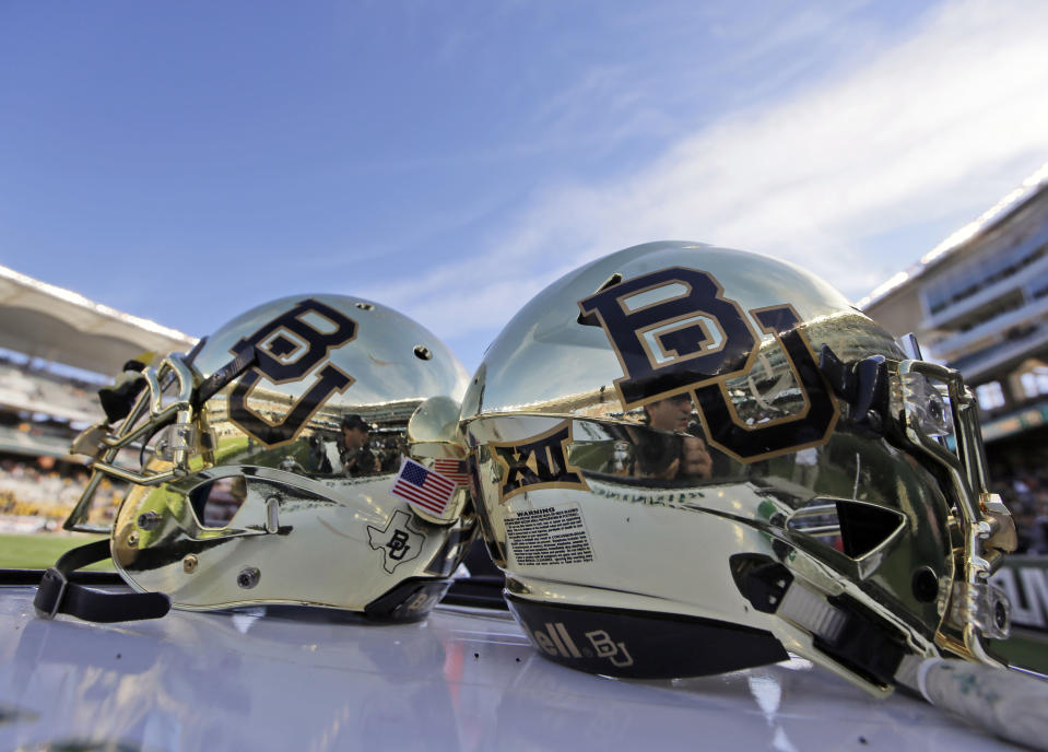 FILE - Baylor helmets rest on the field after an NCAA college football game in Waco, Texas, Dec. 5, 2015. Baylor University has settled a years-long federal lawsuit brought by 15 women who alleged they were sexually assaulted at the nation’s largest Baptist school. (AP Photo/LM Otero, File)