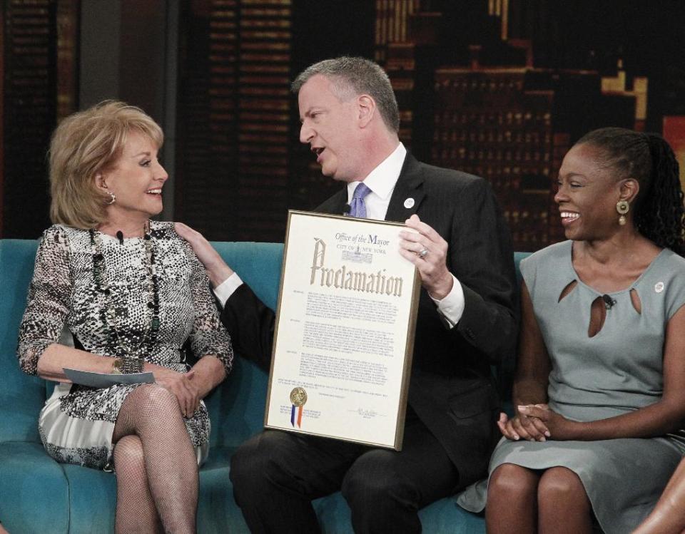 This image released by ABC shows host Barbara Walters, left, with New York City Mayor Bill de Blasio and his wife Chirlane McCray on ABC's "The View," Monday, April 21, 2014 in New York. De Blasio is proclaiming May 16 as “Barbara Walters Day” in New York City. Walters is retiring that day after a storied television reporting career that has spanned five decades. (AP Photo/ABC, Lou Rocco)