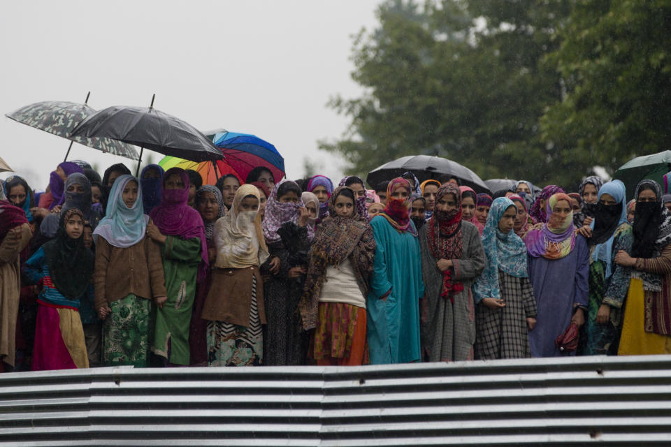 Kashmiri villagers watch the funeral procession of Zakir Musa, a top militant commander linked to al-Qaida, as it rains in Tral, south of Srinagar, Indian controlled Kashmir, Friday, May 24, 2019. Musa was killed Thursday evening in a gunfight after police and soldiers launched a counterinsurgency operation in the southern Tral area, said Col. Rajesh Kalia, an Indian army spokesman. (AP Photo/Dar Yasin)