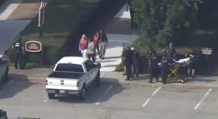 Police evacuate people from a building as a stretcher stands by in this still image taken from video following a shooting incident at the municipal center in Virginia Beach
