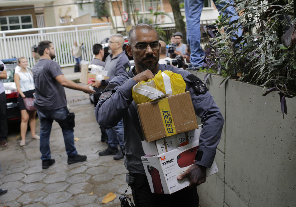 Civil police officers unload items at Civil Police headquarters in Rio de Janeiro, Brazil, Tuesday, March 12, 2019, that were confiscated from the home of the suspects in the killing of councilwoman Marielle Franco. The brazen assassination of the councilwoman and her driver on March 14 last year led to massive protests and widespread anger in Latin America's largest nation. Two suspects have been arrested. (AP Photo/Silvia Izquierdo)