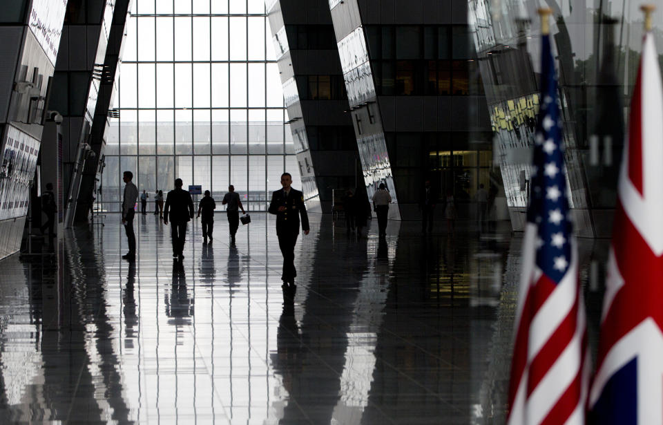 People walk in the main arrival space prior to a meeting of NATO defense ministers at NATO headquarters in Brussels, Wednesday, June 26, 2019. (AP Photo/Virginia Mayo, Pool)