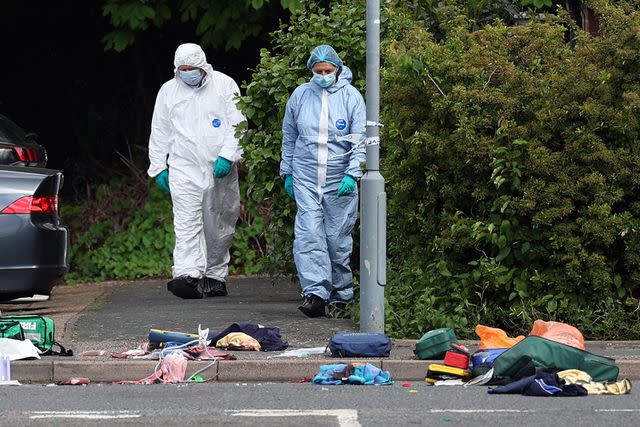 <p>ADRIAN DENNIS/AFP via Getty</p> Forensic police officers examine evidence following the sword attack in the East London neighborhood of Hainault, Tuesday, April 30.