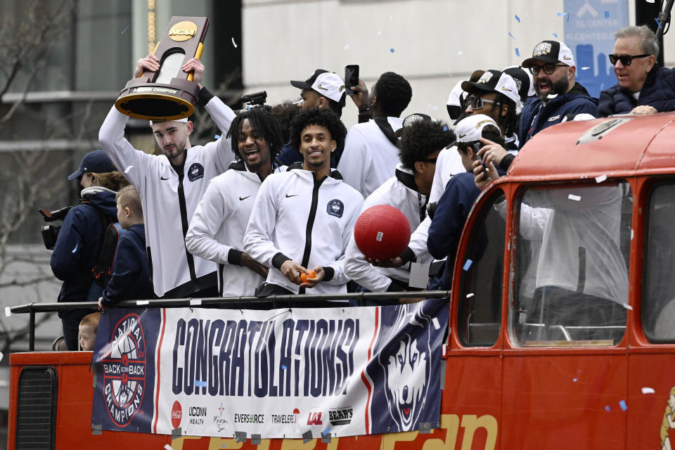 UConn's Alex Karaban, left, holds up the championship trophy during a parade to celebrate the team's NCAA college basketball championship, Saturday, April 13, 2024, in Hartford, Conn. (AP Photo/Jessica Hill)