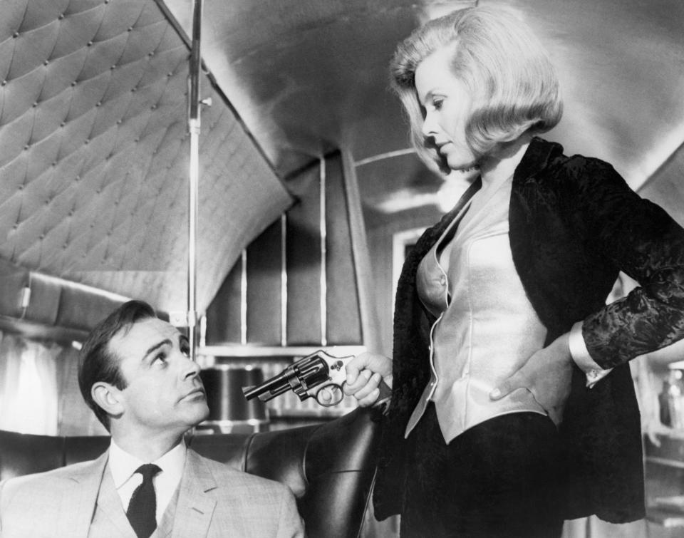 (Original Caption) 1964: A scene from United Artist's production of "Goldfinger," in which James Bond prevents gold smugglers from robbing the United States' gold supply at Fort Knox. In this scene, Honor Blackman as "Pussy Galore" points a gun at Sean Connery as "James Bond." (Photo by �� John Springer Collection/CORBIS/Corbis via Getty Images)