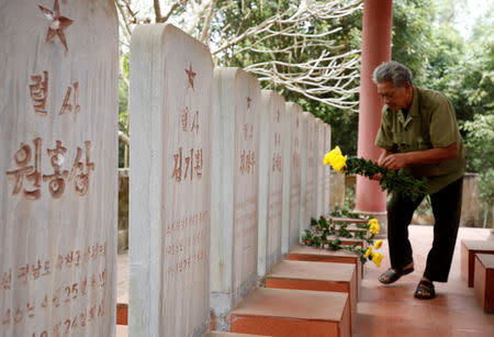 Vietnamese veteran Duong Van Dau places flowers on the headstones of North Korean pilots at the memorial site for North Korean pilots who fought and died during Vietnam War, in Bac Giang province, Vietnam February 13, 2019. Picture taken February 13, 2019. REUTERS/Kham