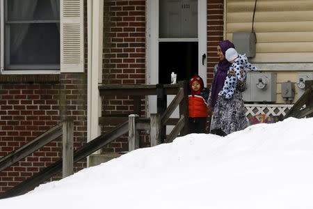 A woman and children watch U.S. President Barack Obama's motorcade arrive at the Islamic Society of Baltimore mosque in Catonsville, Maryland February 3, 2016. REUTERS/Jonathan Ernst