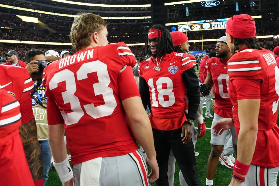 Dec 29, 2023; Arlington, Texas, USA; Ohio State Buckeyes quarterback Devin Brown (33) talks to wide receiver Marvin Harrison Jr. (18) following their 14-3 loss to the Missouri Tigers in the Goodyear Cotton Bowl Classic at AT&T Stadium.