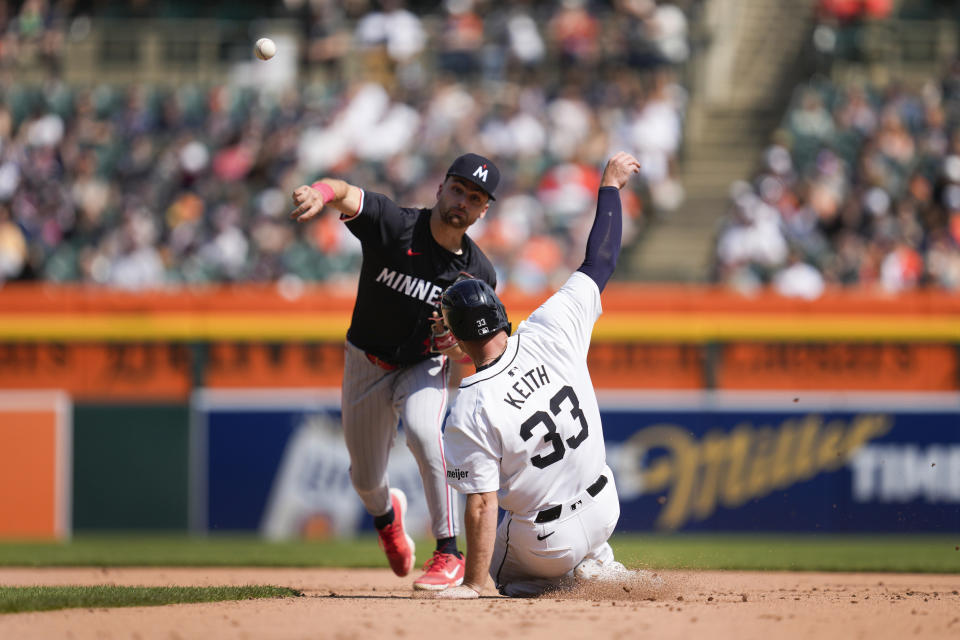 Minnesota Twins second base Edouard Julien (47) throws to first base to complete a double play as Detroit Tigers' Colt Keith (33) slides late into second base in the seventh inning of a baseball game, Sunday, April 14, 2024, in Detroit. (AP Photo/Paul Sancya)