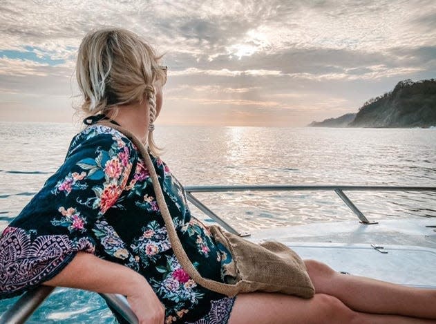 Blonde woman looking off to the sunset from a boat in Costa Rica