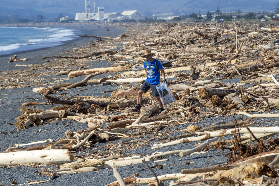 A resident walks amongst the debris washed ashore in Napier, New Zealand from Cyclone Gabrielle, Sunday, Feb. 19, 2023. Cyclone Gabrielle struck the country's north on Feb. 13 and the level of damage has been compared to Cyclone Bola in 1988. That storm was the most destructive on record to hit the nation of 5 million people. (Mark Mitchell/NZ Herald via AP)