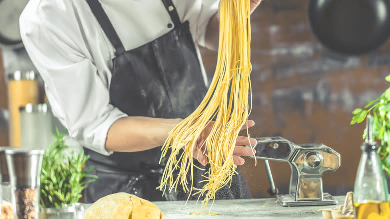 man holding up homemade spaghetti