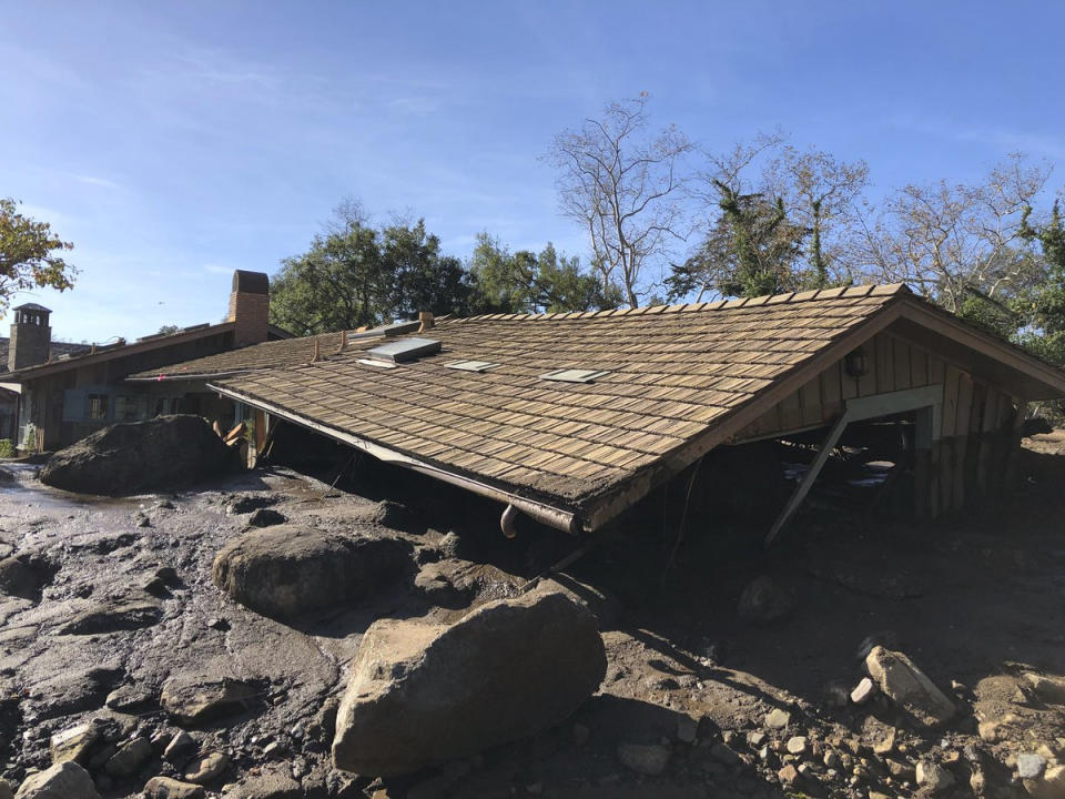 <p>Mudflow, boulders, and debris from heavy rain runoff from early Tuesday reached the roof of a single story home in Montecito, Calif., on Wednesday, Jan. 10, 2018. (Photo: Mike Eliason/Santa Barbara County Fire Department via AP) </p>