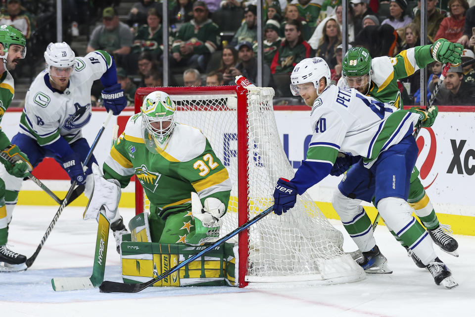 Vancouver Canucks center Elias Pettersson (40) shoots against Minnesota Wild goaltender Filip Gustavsson (32) during the third period of an NHL hockey game Saturday, Dec. 16, 2023, in St Paul, Minn. (AP Photo/Matt Krohn)