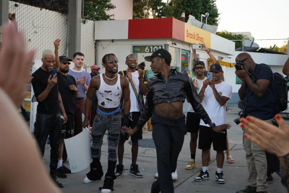 A person dancing at the center of a crowd.