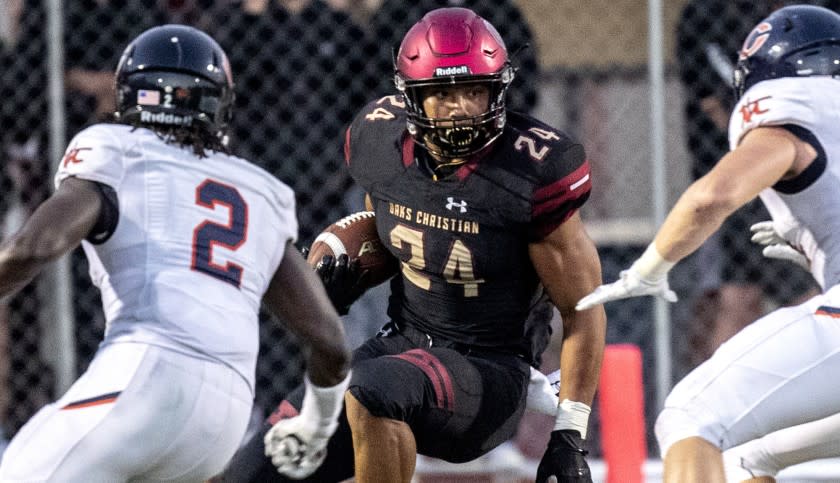 WESTLAKE VILLAGE, CALIF. -- THURSDAY, AUGUST 16, 2018: Oaks Christian's Zach Charbonnet, #24, center, has no where to go on a first quarter run as Chaminade defenders close in during game in Westlake Village, Calif., on Aug. 16, 2018. (Brian van der Brug / Los Angeles Times)