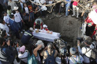 Family members bury 7-year-old murder victim Fatima in Mexico City, Tuesday, Feb. 18, 2020. Fatima's body was found wrapped in a bag and abandoned in a rural area on Saturday. Five people have been questioned in the case, and video footage of her abduction exists. (AP Photo/Marco Ugarte)