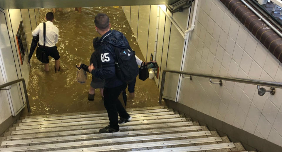 Commuter walk through ankle-deep water at Lewisham Station. Source: Twitter/ Leon Paap