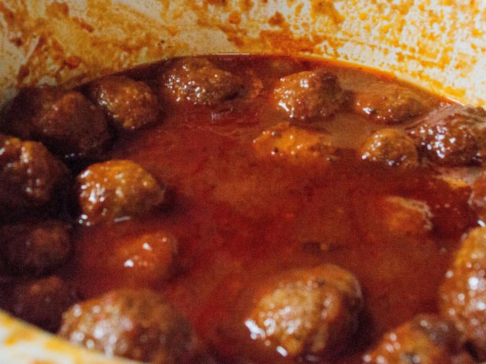 meatballs and sauce in a white slow cooker