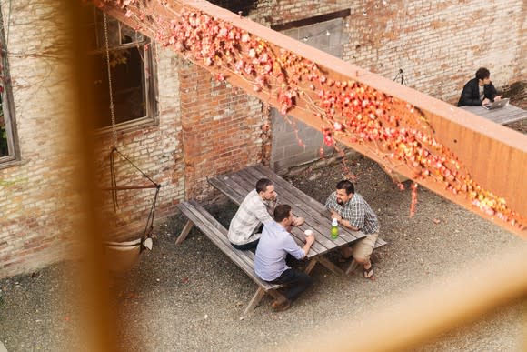 Employees sitting at a picnic table outside Etsy's offices