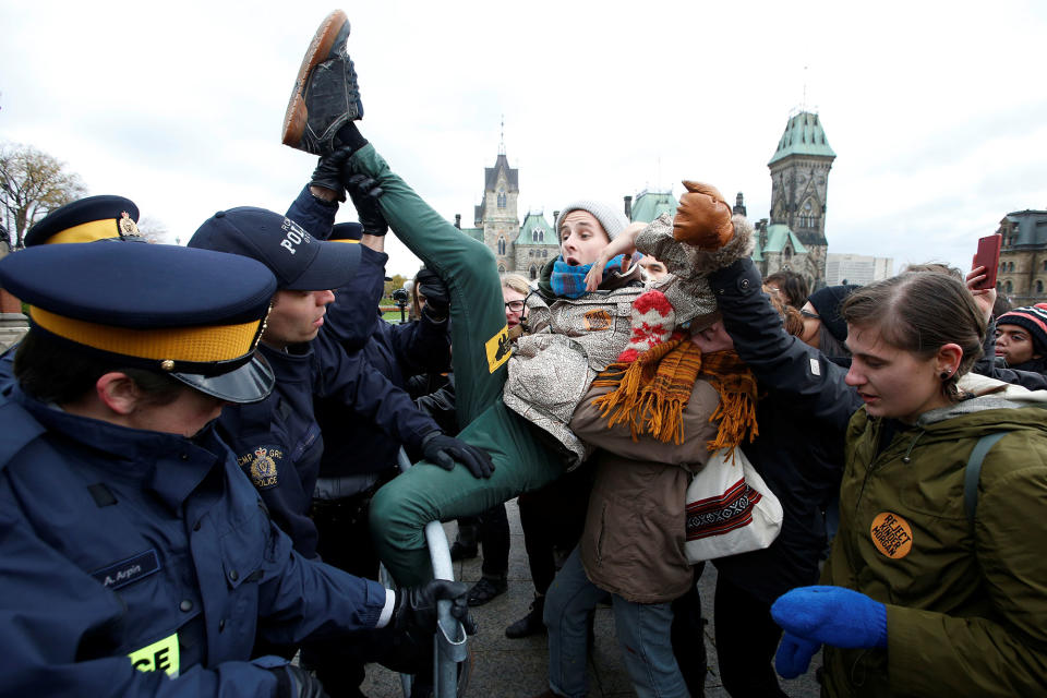 A protestor struggles to cross a police barricade during a demonstration against the proposed Kinder Morgan pipeline on Parliament Hill in Ottawa