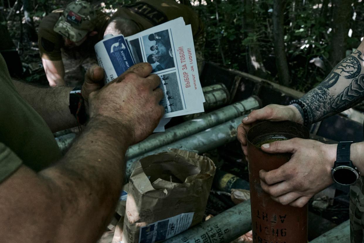 Ukrainian soldiers load flyers urging the Russian soldiers to surrender (AP)