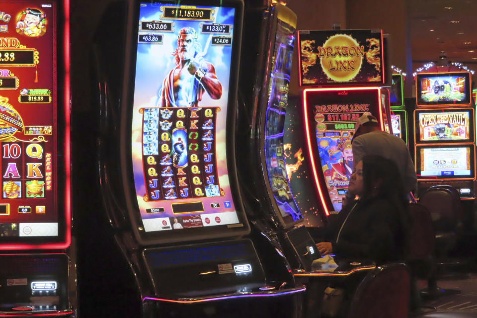 A gambler plays a slot machine at Harrah's casino in Atlantic City, N.J. on Sept. 29, 2023. On Jan, 16, 2023, New Jersey gambling regulators released statistics showing that Atlantic City's casinos, racetracks that accept sports betting and their online partners won nearly $5.8 billion from gamblers in 2023, a new record. But only three of the nine casinos won more from in-person gamblers last year than they did in 2019 before the coronavirus pandemic broke out. (AP Photo/Wayne Parry)